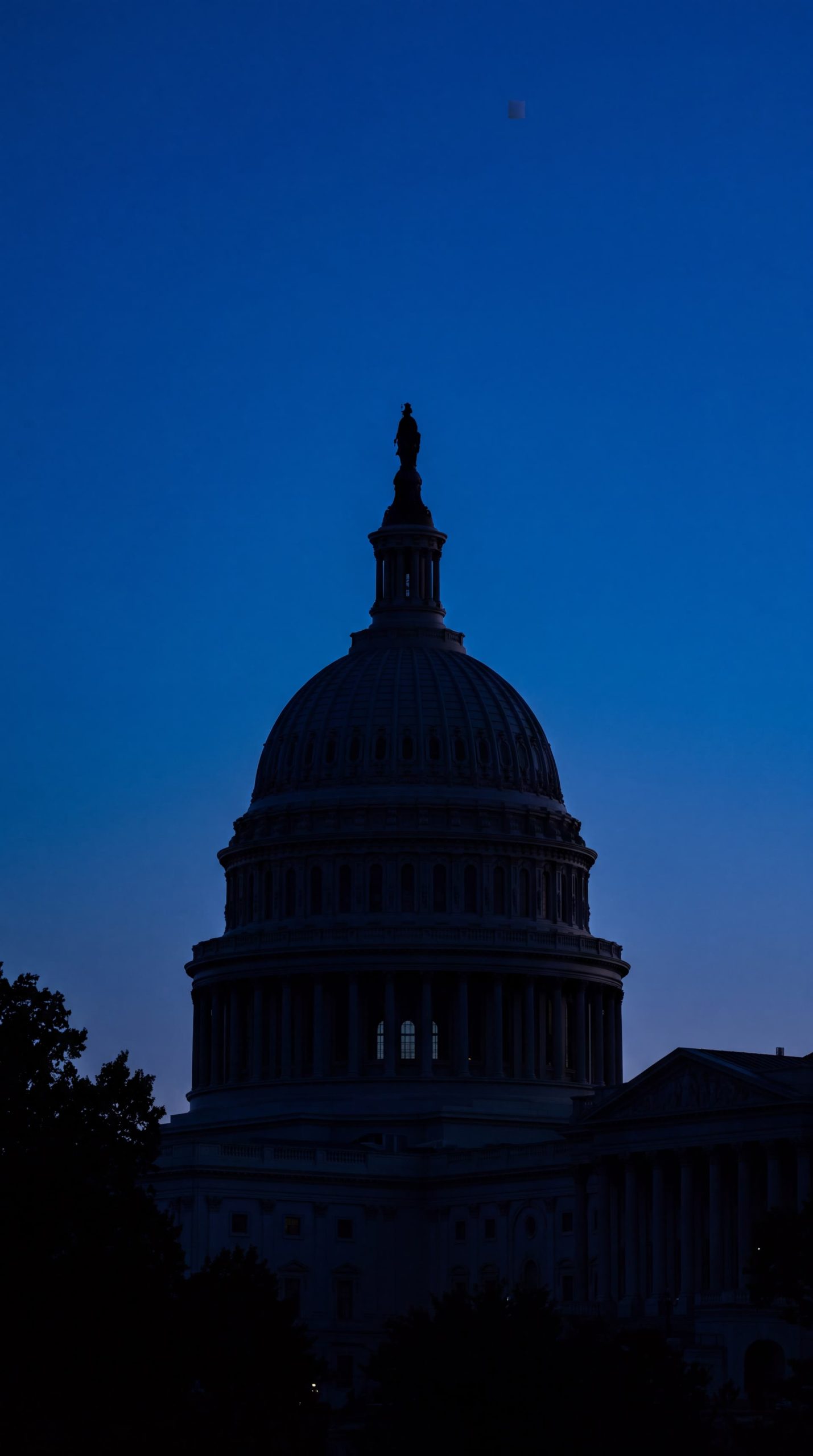 The silhouette of a large dome building against a twilight sky.